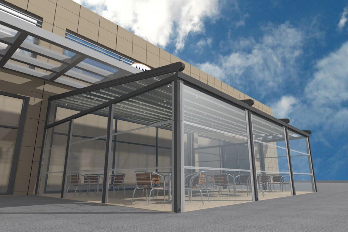 Otomatik giyotin cam sistemleri, dış mekanları dört mevsim kullanılabilir hale getiren motorlu cam sistemleridir. Bu görselde bir kafenin açık alanında uygulanan modern giyotin cam sistemi yer almaktadır.